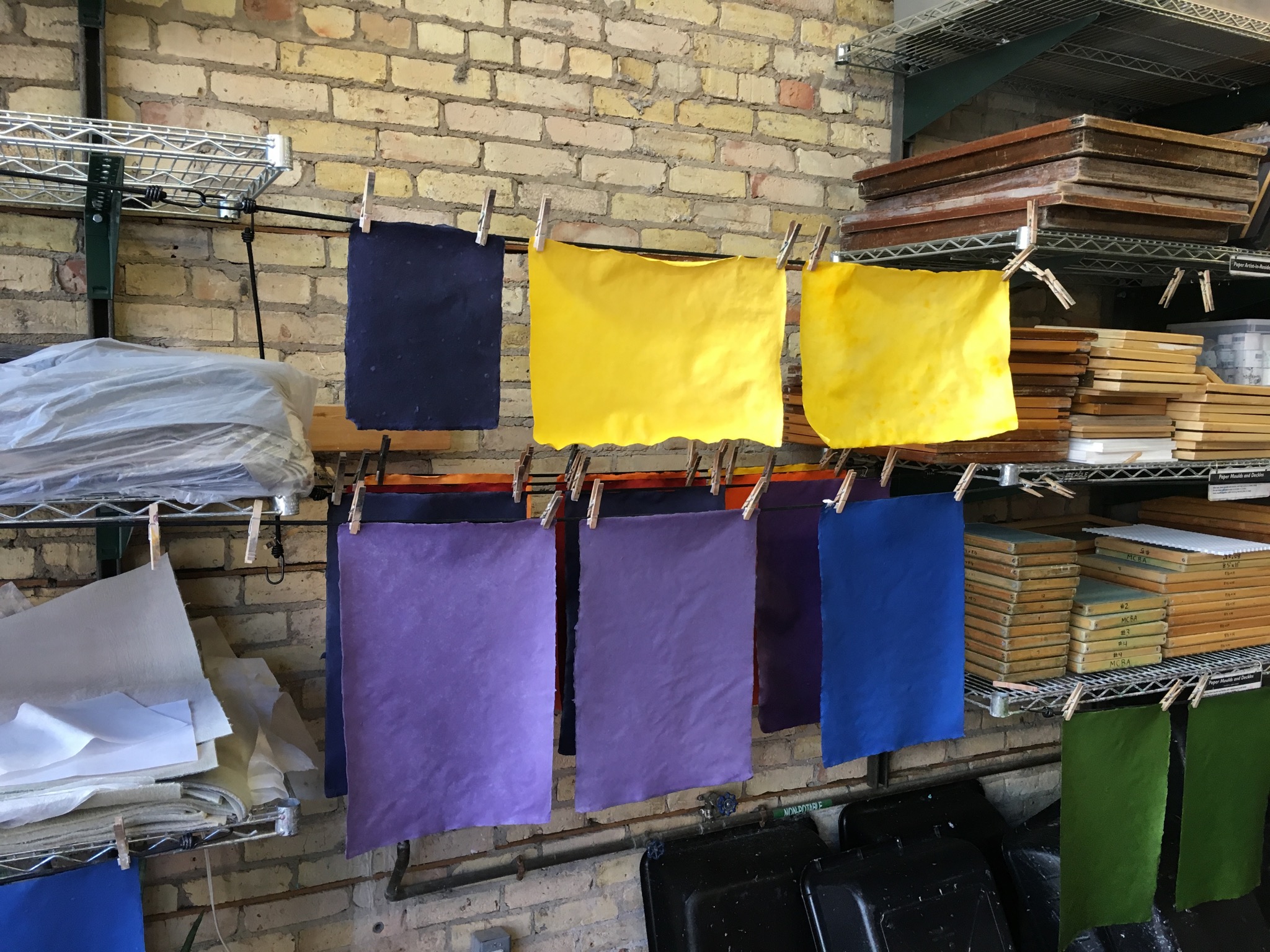 Handmade sheets of paper drying after the colouring process.